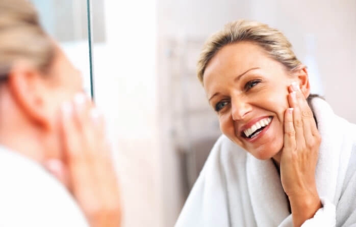 smiling woman looking in mirror